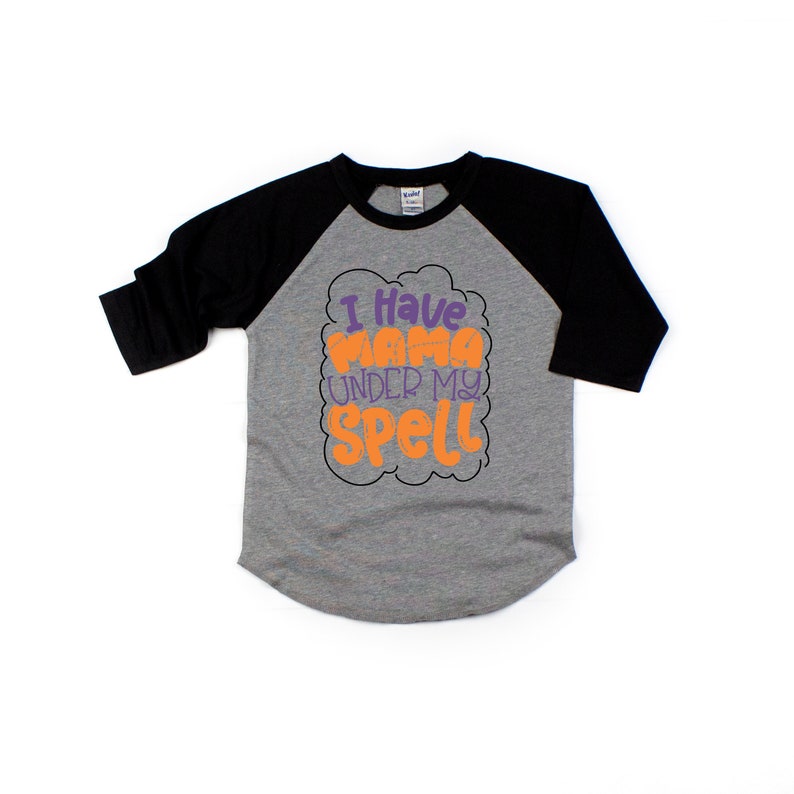 May include: A grey and black baseball tee shirt with the text "I have mama under my spell" in orange and purple lettering.