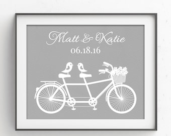 May include: A gray and white printable art print with a white silhouette of a tandem bicycle with two birds perched on the back. The text "Matt & Katie 06.18.16" is printed above the bicycle.