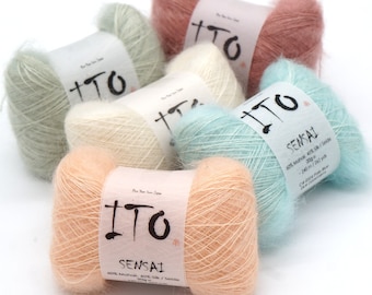 May include: A collection of ITO Sensai yarn skeins in various pastel colors, including peach, pink, mint green, and blue. Each skein has a label with the brand name and fiber content. The yarn is soft and fluffy, ideal for knitting or crochet projects.