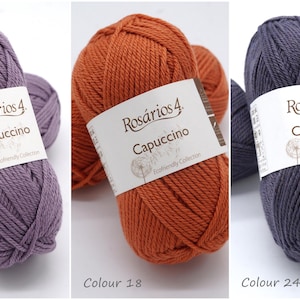 May include: Three balls of yarn in different colours: purple, orange, and grey. Each ball has a label that reads "Ros&aacute;rios 4. Capuccino Ecofriendly Collection".