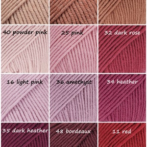 May include: A collection of yarn skeins in various shades of pink, red, and brown. The skeins are arranged in a grid pattern with the color number and name printed on each skein.