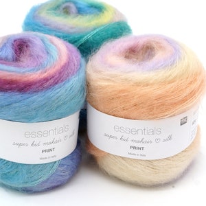Peut inclure: Trois pelotes de fil de différentes couleurs. Le fil est un mélange de super kid mohair et de soie. Les couleurs sont un bleu clair avec des rayures roses et violettes, une pêche claire avec des rayures jaunes et roses, et un bleu sarcelle avec des rayures jaunes et vertes. Le fil est étiqueté "essentials super kid mohair silk PRINT Made in Italy."