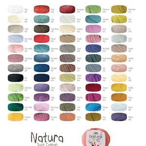 May include: A color chart of DMC Natura Just Cotton yarn. The chart shows 100 skeins of yarn in various colors. The yarn is 50 grams and 155 meters long. The yarn is 100% cotton.