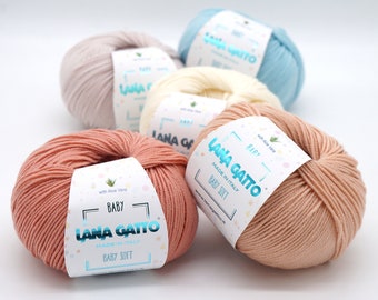 May include: Five balls of yarn in different colors, including pink, beige, light blue, cream, and peach. The yarn is labeled "Lana Gatto Baby Soft" and "Made in Italy".