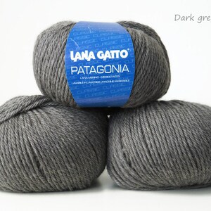 May include: Three balls of dark gray yarn labeled "Lana Gatto Patagonia" with the color code "20742" on the label.