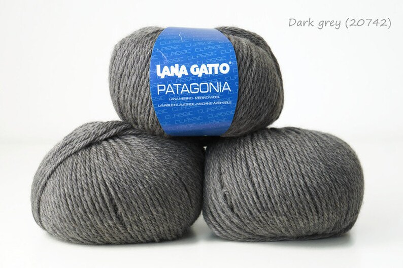 May include: Three balls of dark gray yarn labeled "Lana Gatto Patagonia" with the color code "20742" on the label.