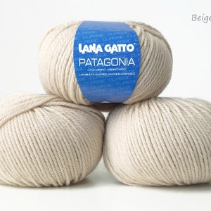 May include: Three balls of beige yarn labeled "Lana Gatto Patagonia" with the color code "Beige (13701)".