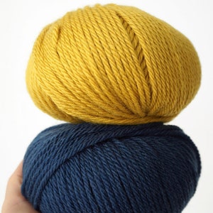 May include: Two balls of yarn, one yellow and one dark blue.