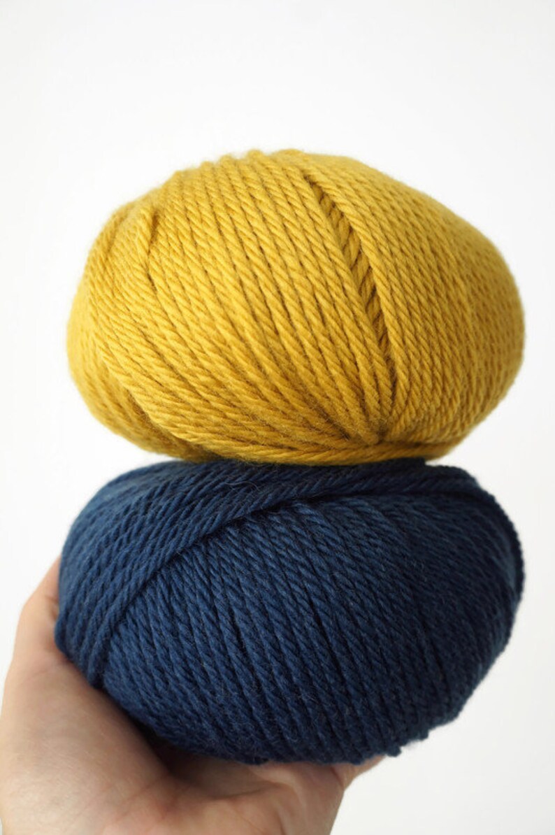 May include: Two balls of yarn, one yellow and one dark blue.