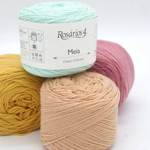 May include: Four balls of yarn in different colors: yellow, peach, light green, and pink. The light green ball has a label that says "Ros&aacute;rios 4 Meia Classic Collection".