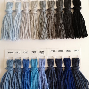 Puede incluir: Una carta de colores con muestras de hilo en varios tonos de gris, azul y negro. La carta incluye los n&uacute;meros de hilo y la palabra "NEW" junto a algunas de las muestras.
