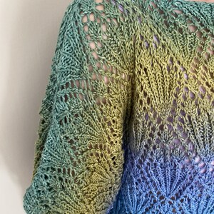 Puede incluir: Un top de crochet de color verde, amarillo y azul con un patr&oacute;n de encaje.