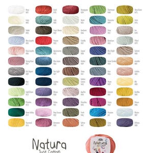 May include: A color chart of DMC Natura Just Cotton yarn. The chart shows 48 different colors of yarn, each with a color name and number. The yarn is 100% cotton and comes in 50 gram skeins with approximately 155 meters of yarn per skein. The yarn is machine washable and can be tumble dried.