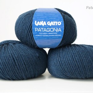 May include: Three balls of dark blue yarn labeled "Lana Gatto Patagonia" with the color "Petrol (5522)".
