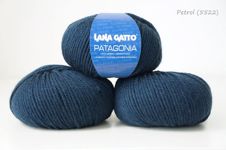 May include: Three balls of dark blue yarn labeled "Lana Gatto Patagonia" with the color "Petrol (5522)".