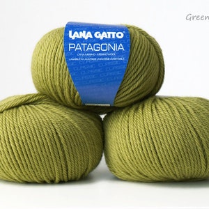 May include: Three balls of green yarn, labeled "LANA GATTO PATAGONIA" in blue. The yarn is a medium weight and is machine washable.