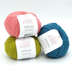 May include: Three balls of yarn in pink, green, and blue. Each ball has a white label with the text "LAINES du NORD made in Italy SPRING WOOL Luxury Line".