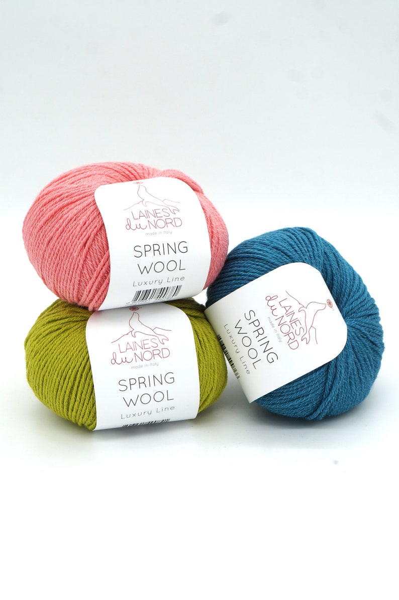May include: Three balls of yarn in pink, green, and blue. Each ball has a white label with the text "LAINES du NORD made in Italy SPRING WOOL Luxury Line".