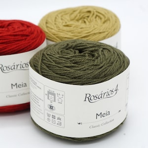 May include: Three balls of yarn in red, yellow, and green. The yarn is labeled "Ros&aacute;rios 4 Meia Classic Collection" and includes care instructions.