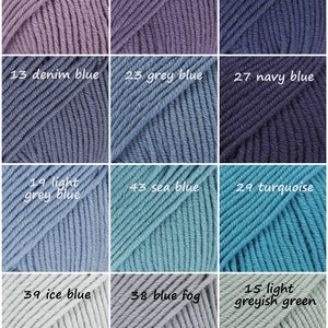 May include: A collection of yarn skeins in various shades of blue, purple, and green. The skeins are arranged in a grid pattern, with each skein labeled with a number and a color name.