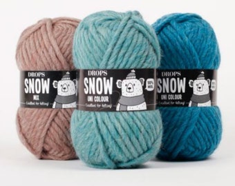 May include: Three skeins of yarn in different colors: brown, teal, and blue. Each skein has a label that says "DROPS SNOW" with a polar bear illustration. The brown skein says "MIX" and the teal and blue skeins say "UNI COLOUR".