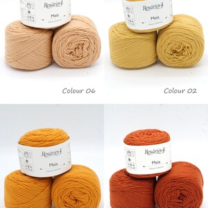 May include: Four balls of yarn in different shades of orange, yellow, and brown. The yarn is labeled "Ros&aacute;rios 4 Meia Classic Collection".
