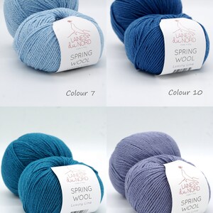 May include: Four skeins of yarn in different shades of blue. The yarn is labeled "Laines du Nord Spring Wool Luxury Line".