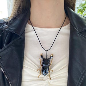 May include: A white ceramic mug with a black handle and the text "But First, Coffee" in a black, handwritten-style font. The mug is on a white surface.