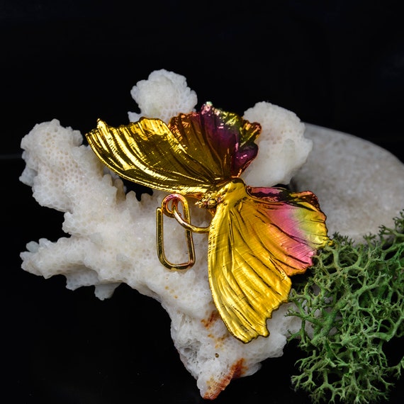 A real butterfly preserved and electroformed in copper — wearable natural history that genuinely stops people mid-conversation.