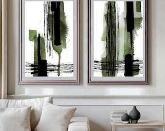 May include: Two framed abstract art prints. Each print features a white background with black and olive green brushstrokes. The artwork includes vertical and horizontal lines, creating a modern aesthetic. The frames are a silver color.