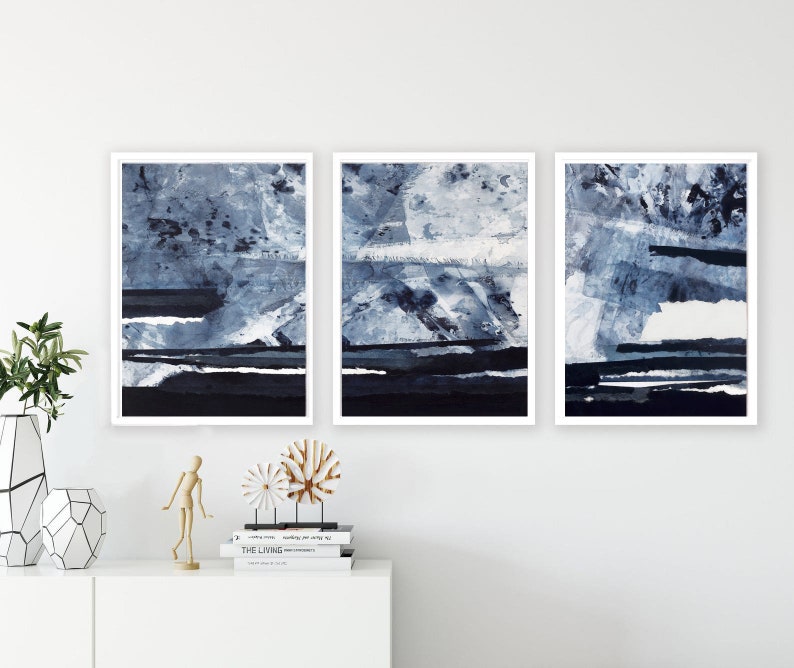 Pu&ograve; includere: Tre stampe d'arte astratta incorniciate in uno schema di colori blu e bianco. Le stampe presentano un design stratificato e testurizzato con sfumature di blu e bianco.