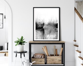 May include: Black and white abstract art print in a black frame hanging above a wooden console table with two wooden storage boxes. The console table has a black metal frame and wheels.