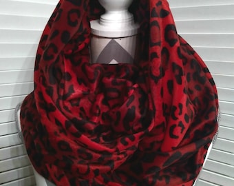 May include: Red and black infinity scarf with a leopard print pattern.