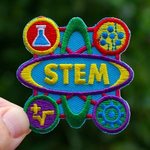 May include: A colorful embroidered patch with the word "STEM" in yellow letters on a blue background. The patch is surrounded by five smaller circles, each with a different symbol representing science, technology, engineering, and math.