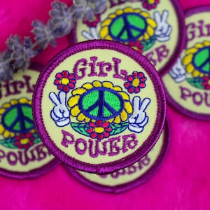 May include: Four yellow and purple embroidered patches with a peace sign, flowers, and the text "Girl Power".