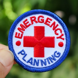 May include: A blue and white embroidered patch with a red cross and the text "Emergency Planning".