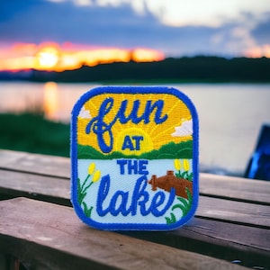 May include: Blue and yellow embroidered patch with the text "Fun at the Lake" and a sun graphic.