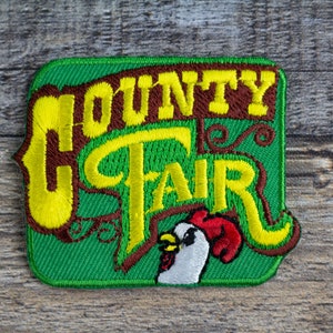 May include: Green embroidered patch with yellow lettering that reads "COUNTY FAIR" and a brown rooster illustration.