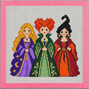 May include: A needlepoint canvas featuring three figures with stylised hair and dresses. The left figure has long yellow hair and a purple dress with moon and star motifs. The centre figure has orange hair and a green dress. The right figure has black hair and a red dress.