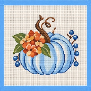 May include: A needlepoint canvas featuring a light blue pumpkin with a brown stem and curly vine. The pumpkin is decorated with a cluster of orange flowers, green leaves, and small blue berries on brown stems, all set against a white grid background.