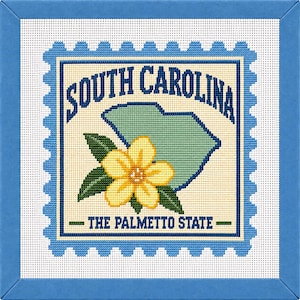 May include: A square needlepoint canvas featuring a postage stamp design with a light blue scalloped border. The center displays a light green map of South Carolina, a yellow flower with green leaves, and the text South Carolina The Palmetto State.