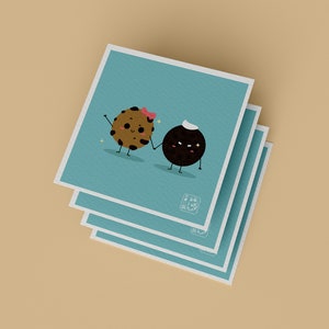 May include: A stack of three blue cards with a cartoon illustration of a chocolate chip cookie and a black cookie holding hands. The chocolate chip cookie is wearing a pink bow and the black cookie is wearing a white sailor hat.