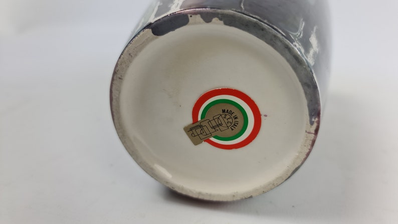 Puede incluir: Un jarr&oacute;n de cer&aacute;mica con interior blanco y exterior oscuro con dise&ntilde;o veteado. La base del jarr&oacute;n tiene una pegatina con los colores de la bandera italiana y la inscripci&oacute;n "MADE IN ITALY".