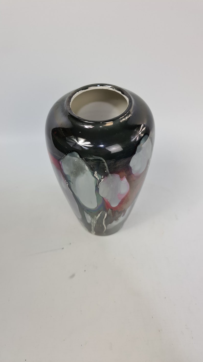 Puede incluir: Un jarr&oacute;n decorativo con un acabado negro brillante y una abertura ancha. El jarr&oacute;n presenta detalles abstractos grises, blancos y rosas. El interior es blanco. Este jarr&oacute;n es adecuado para la decoraci&oacute;n del hogar.