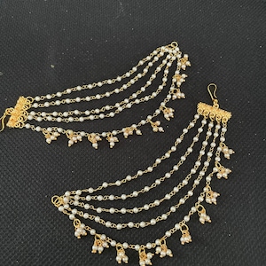 May include: A pair of gold-tone ear cuffs with multiple strands of white pearl beads and small pearl drops.