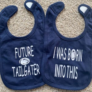 May include: Two blue baby bibs with white text. One bib says "Future Tailgater" with a white football graphic. The other bib says "I Was Born Into This" with a white football graphic.