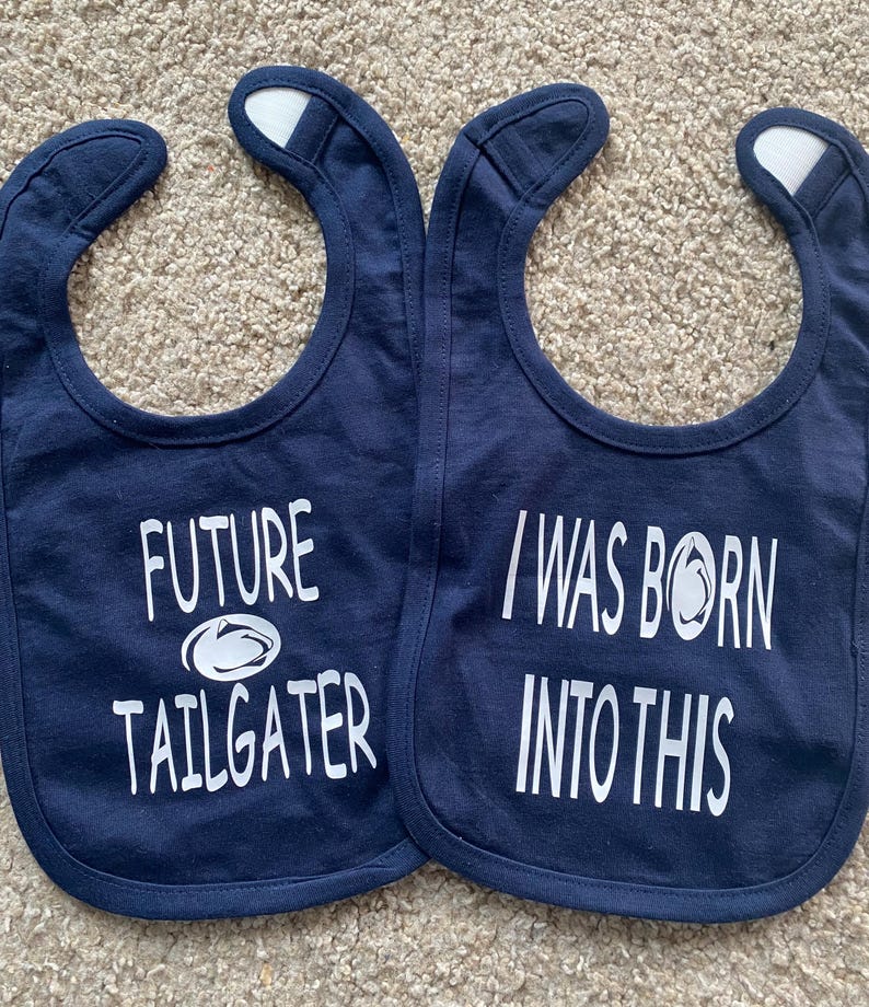 May include: Two blue baby bibs with white text. One bib says "Future Tailgater" with a white football graphic. The other bib says "I Was Born Into This" with a white football graphic.