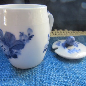 Peut inclure: Tasse à thé en céramique blanche avec un couvercle assorti. La tasse et le couvercle sont décorés de motifs floraux bleus. La tasse a une petite anse. Le couvercle a un petit bouton et une encoche pour une cuillère.