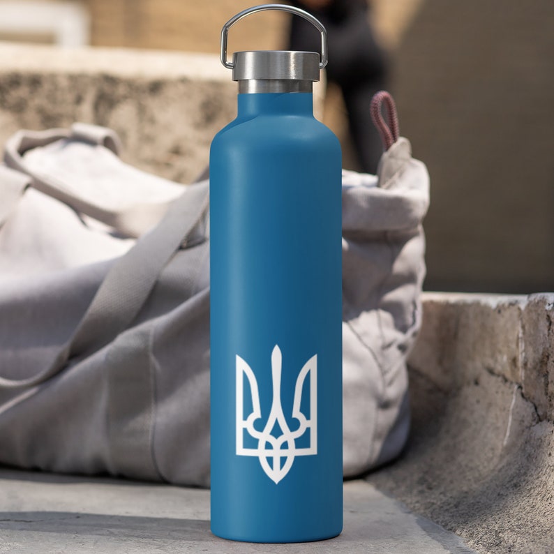 May include: A blue stainless steel water bottle with a white trident symbol. The bottle has a screw-on lid and a carrying handle.