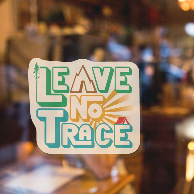 May include: A sticker with a green, brown, and blue design that says "Leave No Trace" with a sun and a red tent.